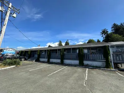 a building with vines on the side of a parking lot at Island West Resort-Motel in Ucluelet