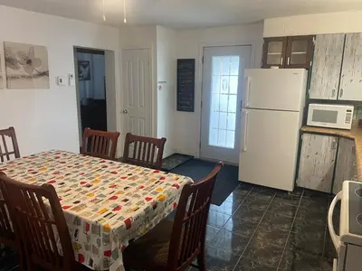 a kitchen with a table and a white refrigerator at Large Farm in Bélanger