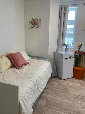a bedroom with a bed and a small refrigerator at ArtHaus Downtown Jim Robb Unit 3BR 3BA in Whitehorse