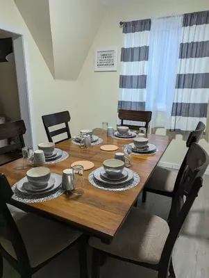 a wooden table with chairs and plates and bowls on it at 347 Des Meurons Street Unit A and Unit B in Bélanger