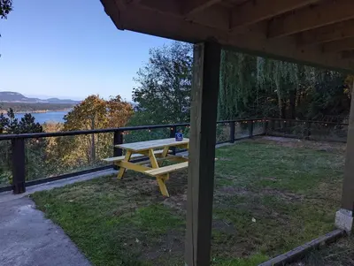 a wooden picnic table sitting on top of a porch at The Mushroom Manor B&B and Cedar Sauna in Salt Spring Island