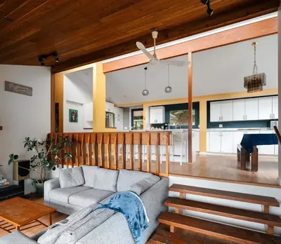 a living room with a couch and a kitchen at The Mushroom Manor B&B and Cedar Sauna in Salt Spring Island