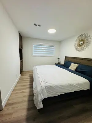 a bedroom with a large bed and a mirror at Ricky's Apartment in Delta