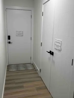 a hallway with two white doors and a wooden floor at Ricky's Apartment in Delta