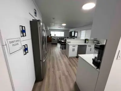 a kitchen with a refrigerator and a dining room at Ricky's Apartment in Delta