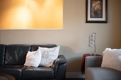 a living room with a leather couch with pillows at Cozy 3BR Family Home near City Centre & SkyTrain in Coquitlam