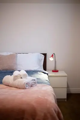 a bedroom with a bed with towels on it at Cozy 3BR Family Home near City Centre & SkyTrain in Coquitlam