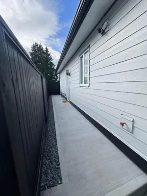 a sidewalk next to a building with a fence at Brand new fully private Garden Suite 1 in Delta