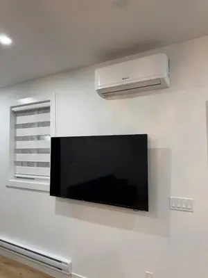 a flat screen tv hanging on a white wall at Brand new fully private Garden Suite 1 in Delta