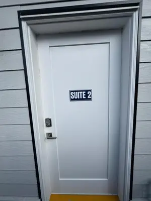 a white garage door with a sign that reads suite at Brand new fully Private Garden suite 2 in Delta