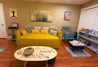 a living room with a yellow couch and a table at A Room of One's Own-A perfect getaway by the sea in North Nanaimo in Nanaimo
