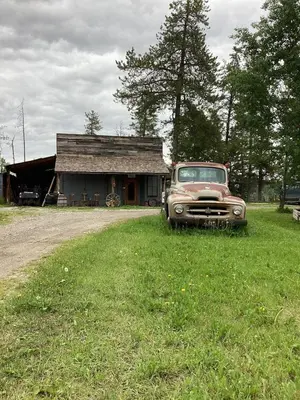 an old truck parked in front of a house at Cozy Country Log Cabin Art Spa Getaway in Caroline