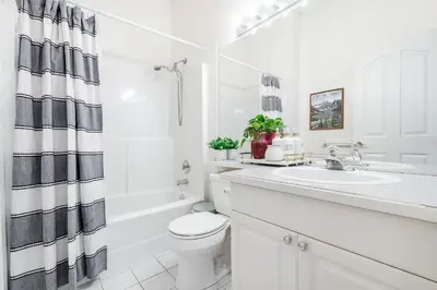 a white bathroom with a sink and a toilet at Surrey Nature Retreat 4BDR Home in Surrey