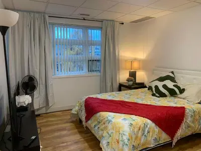 a bedroom with a bed and a large window at ArtHaus Downtown Emma Barr Unit 3BR 1BA in Whitehorse