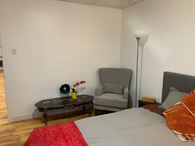 a bedroom with a bed and a chair and a table at ArtHaus Downtown Emma Barr Unit 3BR 1BA in Whitehorse