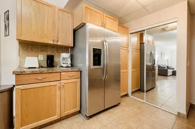 a kitchen with a stainless steel refrigerator and wooden cabinets at Cozy Canmore 2-Bedroom Retreat in Canmore