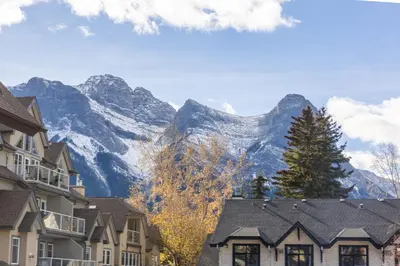 a mountain in the distance with houses and trees at Cozy Canmore 2-Bedroom Retreat in Canmore