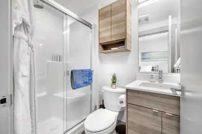 a bathroom with a toilet and a shower and a sink at Vita Resort Vernon - Modern Studio on Okanagan Lake in Vernon