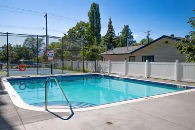 a swimming pool in a yard with a fence at Vita Resort Vernon - Modern Studio on Okanagan Lake in Vernon