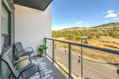 a balcony with chairs and a view of a road at Vita Resort Vernon - Modern Studio on Okanagan Lake in Vernon