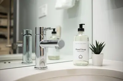 a bathroom sink with a bottle of hand soap and a mirror at Englewood Greens 40 by Outpost Whistler in Whistler
