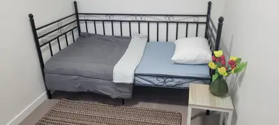 a bed in a room with a vase of flowers at Single Court in Abbotsford