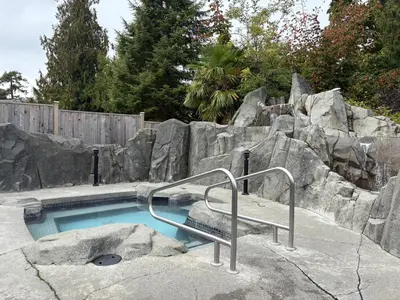 a small swimming pool with a rock wall at Oceanside Getaway in Nanoose Bay