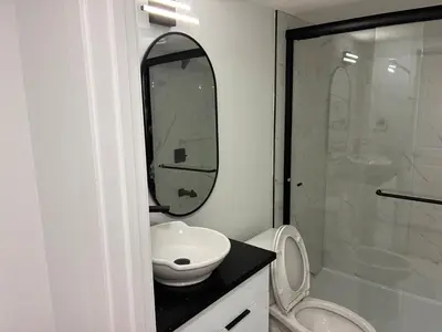 a bathroom with a toilet and a sink and a mirror at Home away from Home in Edmonton