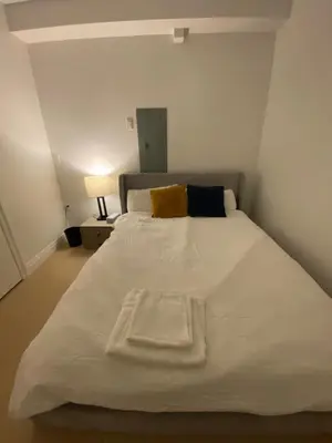 a large white bed with a yellow pillow on it at Sunshine A in Vancouver