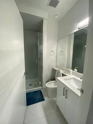 a white bathroom with a sink and a toilet at Sunshine A in Vancouver