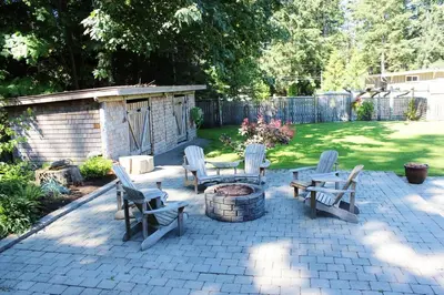 a patio with chairs and a table and a fire pit at Saratoga beach cabin with hot tub in Oyster Bay
