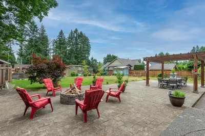 a patio with red chairs and a fire pit at Saratoga beach cabin with hot tub in Oyster Bay