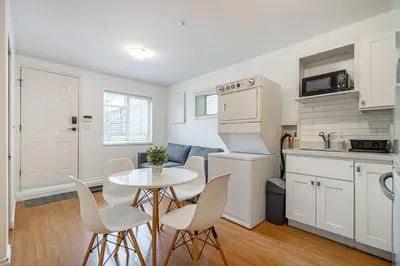 a kitchen and dining room with a table and chairs at Private Guest Suite with Kitchen in Vancouver