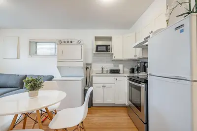 a kitchen with a table and a white refrigerator at Private Guest Suite with Kitchen in Vancouver