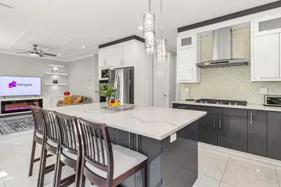a kitchen with a large island with chairs in it at 8BR New Spacious Home White Rock HVAC Free Parking in Surrey