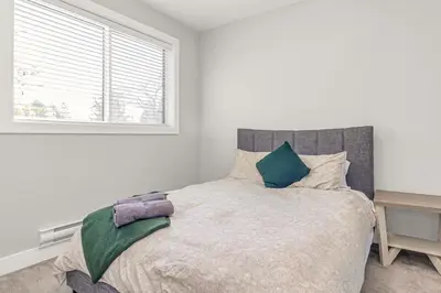 a bedroom with a large bed with a window at 8BR New Spacious Home White Rock HVAC Free Parking in Surrey