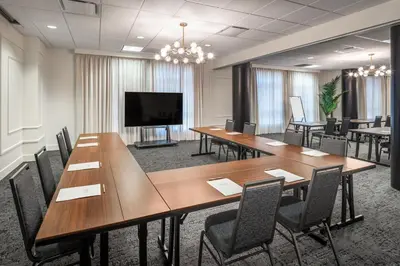 a conference room with tables and chairs and a flat screen tv at Residence Inn by Marriott Calgary South in Calgary