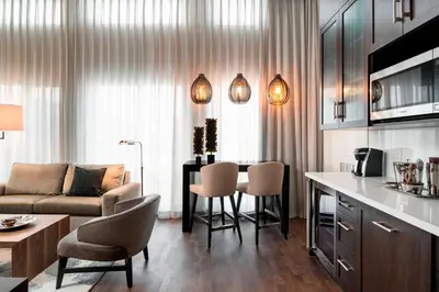 a living room with a couch and a table and chairs at Courtyard by Marriott Calgary South in Calgary
