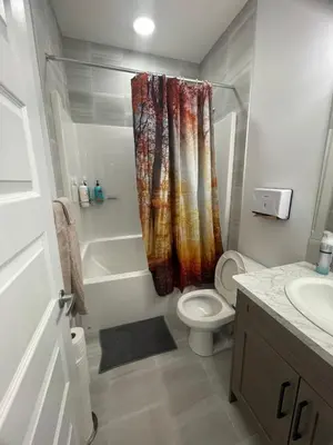 a bathroom with a toilet and a shower curtain at Exquisite 4BR & 3 Baths 2000sqft Home in Calgary