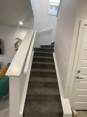 a staircase in a house with white walls and carpet at Exquisite 4BR & 3 Baths 2000sqft Home in Calgary