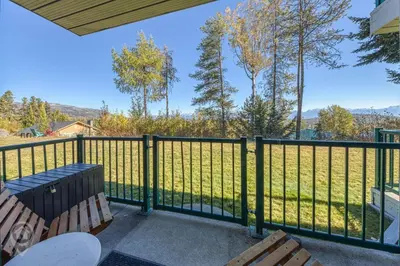 a balcony with benches and a fence with a view of a field at InnWest by StayIn in Kimberley