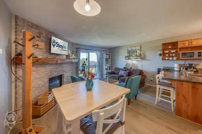 a kitchen and living room with a brick fireplace at InnWest by StayIn in Kimberley