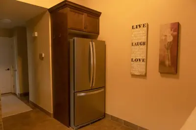 a kitchen with a stainless steel refrigerator next to a wall at Mi Light House \u7c73\u62c9 in Yellowknife