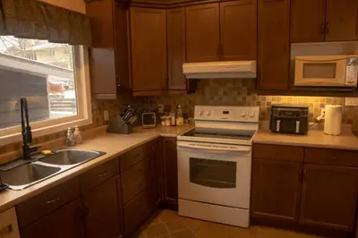 a kitchen with a white stove top oven next to a sink at Mi Light House \u7c73\u62c9 in Yellowknife
