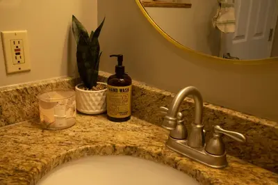 a bathroom sink with a bottle of soap and a mirror at Mi Light House \u7c73\u62c9 in Yellowknife