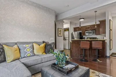 a living room with a couch and a kitchen at Amazing Views 1BR Condo with Hot Tub and Pool in Canmore