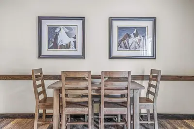 a dining room table with chairs and two pictures on the wall at 2BR Scenic Rockies Retreat BBQ Hot Tub and Pool in Canmore