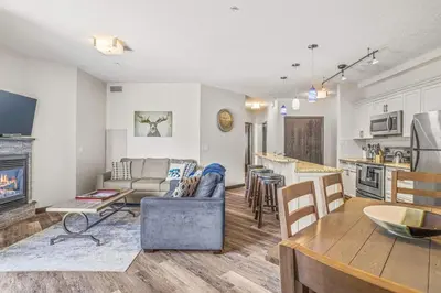 a living room and kitchen with a couch and a table at 2BR Scenic Rockies Retreat BBQ Hot Tub and Pool in Canmore