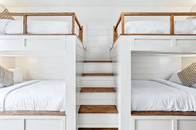 two bunk beds in a room with white walls at Mountain View Penthouse 3BR with Private Hot Tub in Canmore
