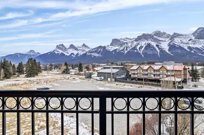 a view from the balcony of a resort with snow covered mountains at Mountain View Penthouse 3BR with Private Hot Tub in Canmore